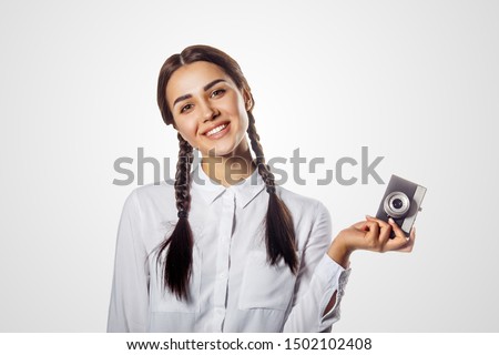 Smiling girl with retro vintage camera. Pretty model making photo