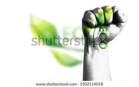 Ecological logo is shown on a man hand clenched into a fist. The Concept of Ecology with Environmental Pollution from Domestic and Industrial Waste.