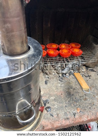 Cooking at camp, cooking tomatoes and eggs on the grill, metal tea pot boiling, barbecuing