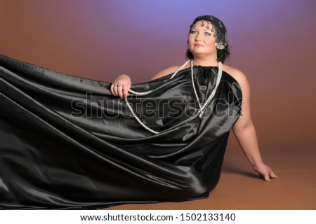 woman in oriental robes in black with pearls around her neck