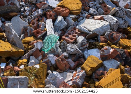 Debris of concrete, brick, glass, wood, pieces of foam rubber, landfill construction waste close-up