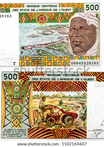 African man's face and a dam, Portrait from African States, 500 Francs 1961 banknote. The letter "T" in Togo, African States money. 