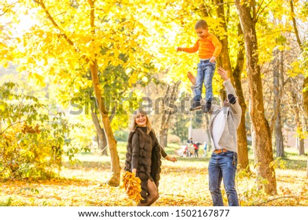 Family playing in autumn park having fun