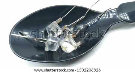 A picture of LED bulbs on a black spoon