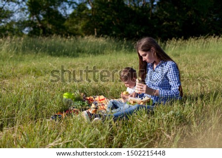 Mom and son eat in park picnic in nature family