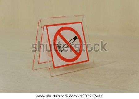 Acrylic no smoking sign on gray wooden table.Shallow depth of field.Health concept.