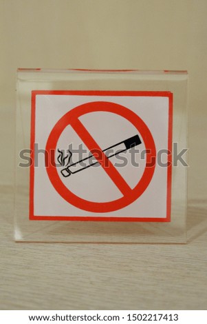 Selective focus of acrylic no smoking sign on gray wooden table. Health concept.
