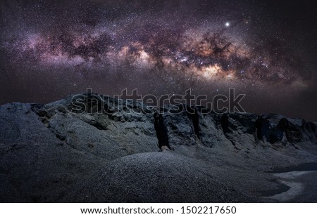 Panorama view of universe space shot of nebula and milky way. Milky way galaxy on hill under amazing starry blue night sky. Silhouette of Snow Mountain Grand Canyon of Chonburi, Stonehenge of Thailand