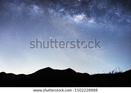 Panorama view of universe space shot of nebula and milky way galaxy with stars on blue night sky . Milky way galaxy with hill under amazing starry night sky. Silhouette of Mountain and skyline
