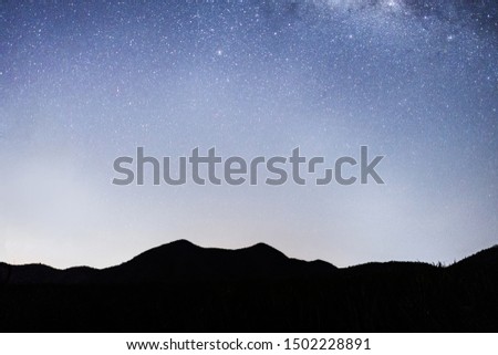 Panorama view of universe space shot of nebula and milky way galaxy with stars on blue night sky . Milky way galaxy with hill under amazing starry night sky. Silhouette of Mountain and skyline