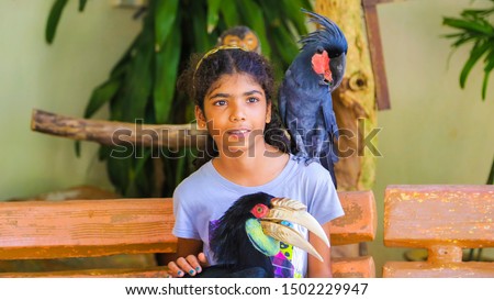 Parrot posing with young girl for photo