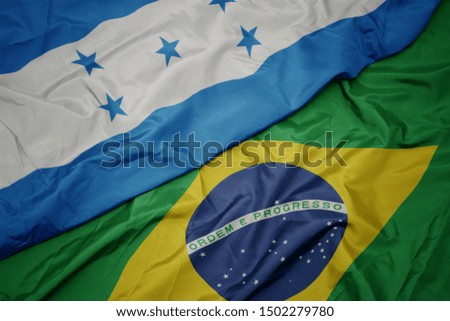 waving colorful flag of brazil and national flag of honduras. macro