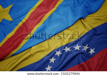 waving colorful flag of venezuela and national flag of democratic republic of the congo. macro