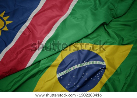 waving colorful flag of brazil and national flag of namibia. macro