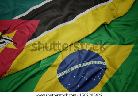 waving colorful flag of brazil and national flag of mozambique. macro