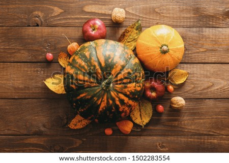Happy Thanksgiving concept. Creative layout with ripe orange pumpkins, fallen leaves, dry flowers on rustic wooden table. Flat lay, top view, copy space.
