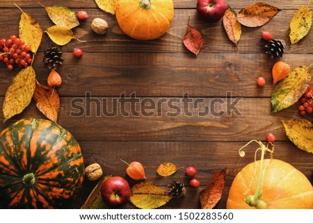 Happy Thanksgiving concept. Autumn composition with ripe orange pumpkins, fallen leaves, dry flowers on rustic wooden table. Flat lay, top view, copy space. 