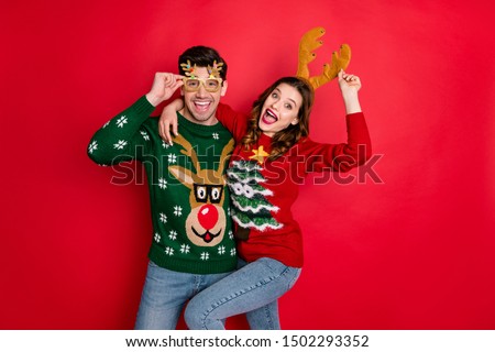 Portrait of crazy two people wife husband student hipster hug embrace wear brown comfort cozy pullover sweater with chritsmas tree design denim jeans eyewear isolated over red color background Royalty-Free Stock Photo #1502293352