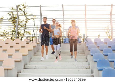 Group of sporty young people training at the stadium
