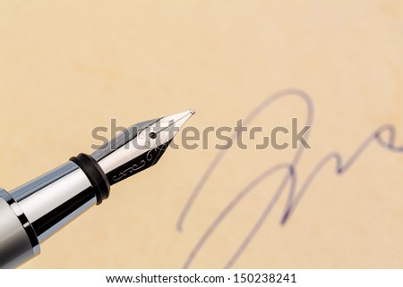 a fountain pen and a signature on yellow paper. symbolic photo for contract, and graphology testament