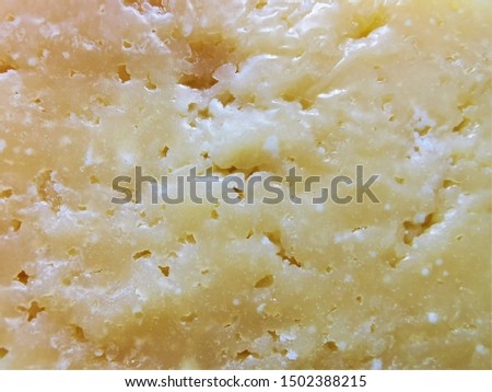 The surface of hard aged Parmesan cheese. Close-up photo
