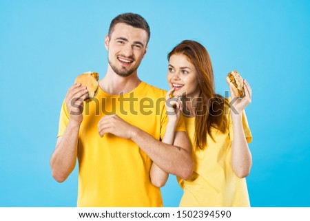 hamburger fast food woman blue background man yellow shirt