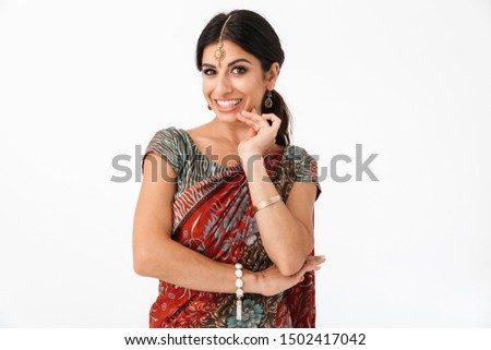Portrait of pleased hindus girl wearing traditional indian costume lehenga choli or saree dress and ethnic jewelry isolated over white background