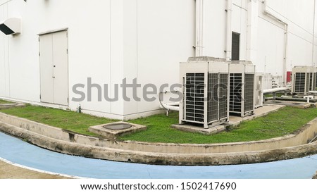 Air conditioning out door,A group of three industrial sized air conditioners along a brick wall,Air conditioning with extra door for maintenance
