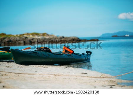Photo of kayak on sandy seashore, blue sky in Norway on summer.