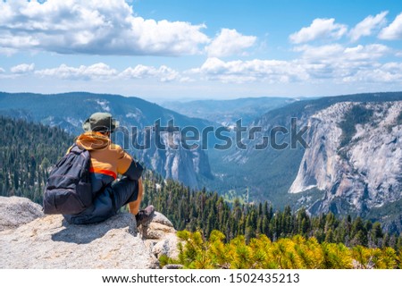 A young man sitting at the Sentinel Dome viewpoint in Yosemite National Park. United States Royalty-Free Stock Photo #1502435213