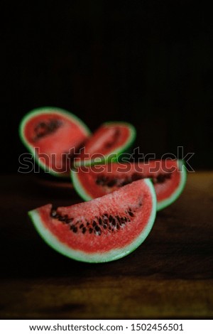 Watermelon slices shot on wooden table in natural light.