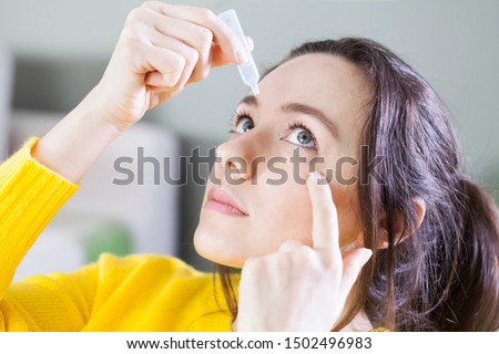 Young woman uses eye drops for eye treatment. Redness, Dry Eyes, Allergy and Eye Itching Royalty-Free Stock Photo #1502496983