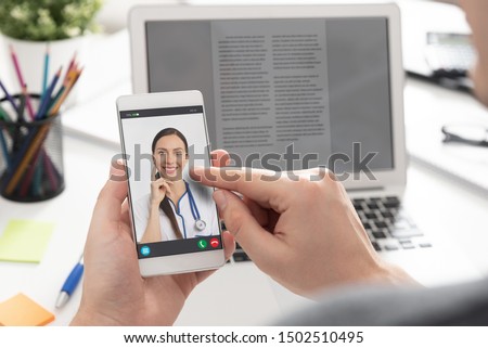 Doctor with a stethoscope on the smartphone screen. Telemedicine or telehealth concept. Royalty-Free Stock Photo #1502510495