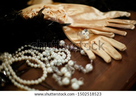 Beige satin gloves decorated with white beads, ring and beads Royalty-Free Stock Photo #1502518523