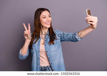 Portrait of positive cheerful woman take selfie on her cellphone have video call feel content make v-signs on her vacation holidays wear denim jeans clothes isolated over grey color background