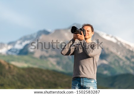 Closeup of man photographing mt Sopris mountain in Carbondale, Colorado town view with snow mountain peak and sky in summer during sunset