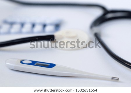 Digital Thermometer with other medicine things on a white table