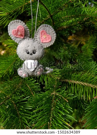 New Year 2020 symbol - rat. Christmas felt decoration on a spruce branch. Handmade bauble figurines symbol of the year - mouse. Holiday background with a copy space.