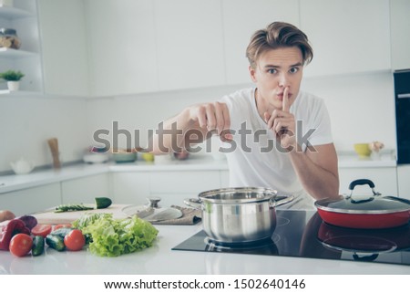 Portrait of his he nice attractive lovely cute guy making organic lunch dinner salting boiling bouillon water at light white modern style interior house indoors Royalty-Free Stock Photo #1502640146