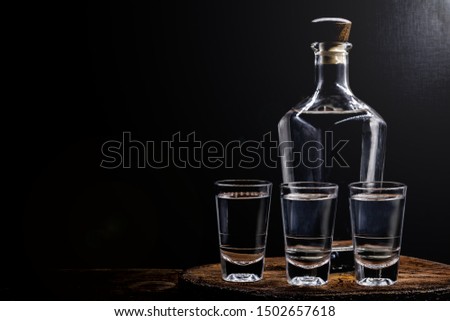 Aguardiente or aguardente Traditional Spanish and Brazilian alcoholic drink, strong drink, grape brandy, rum, gin, silver tequila, pinga, Brazilian cachaça, Russian vodka, in glasses on an old rustic Royalty-Free Stock Photo #1502657618