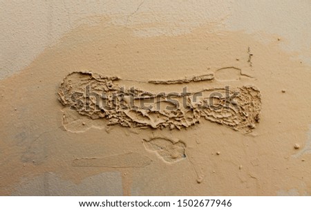 Old beige wall with falling stucco
