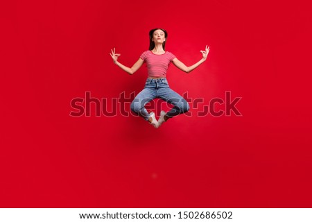 Full length body size photo of practicing girlfriend wearing jeans denim striped t-shirt while isolated over red background
