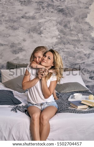 Mother and her daughter child girl playing and hugging. Loving young mother laughing, hugging smiling cute funny baby daughter, enjoying time together at home. Happy loving family.