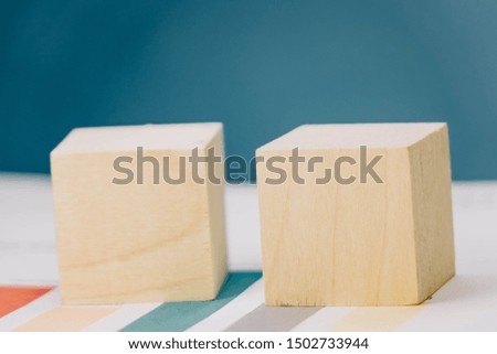 template in the form of two wooden cubes lying on a bundle of documents on a blue background