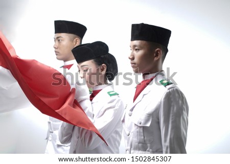 Close up photo Indonesian National Flag Hoisting Troop kissing flag. National Paskibraka Council isolated in white Royalty-Free Stock Photo #1502845307