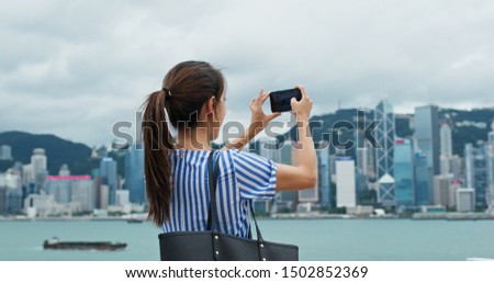Woman use of mobile phone to take photo in Hong Kong city