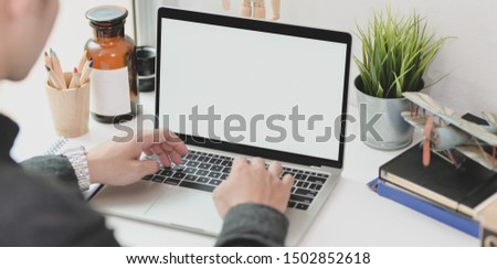 Young professional businessman working on his current marketing plan while typing on laptop computer 