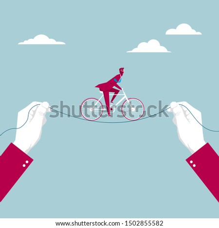 Businessman is riding a bicycle between two hands. Isolated on blue background.