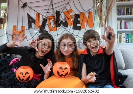 Group of girl and boy kids dress up costume and hold the pumpkin bowl for trick or treat for Halloween day theme coming soon together