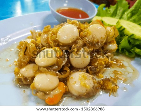 Fried scallops with garlic served with fresh vegetables and chili sauce. Royalty-Free Stock Photo #1502866988